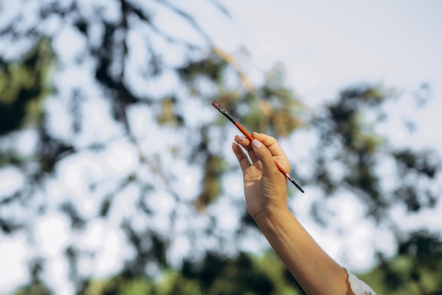 artist holding a paint brush closeup