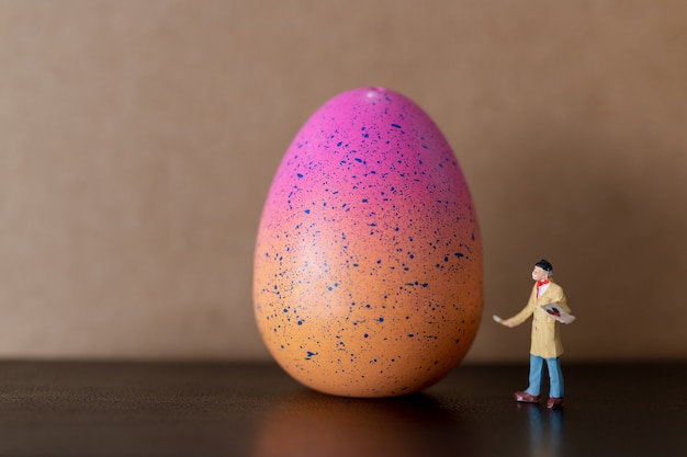  Artist is holding a brush and paint Easter-eggs 