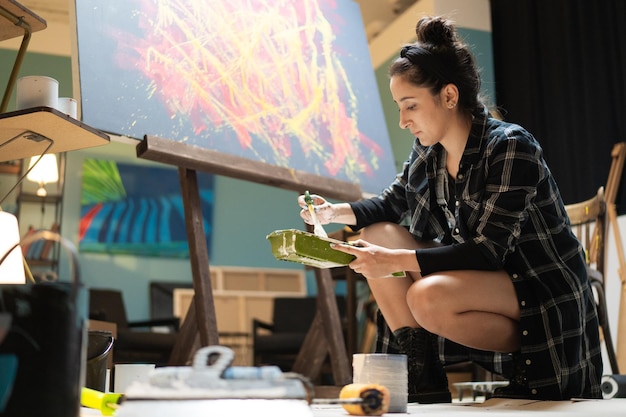 An artist is working in her studio school and art class on a new piece of painting