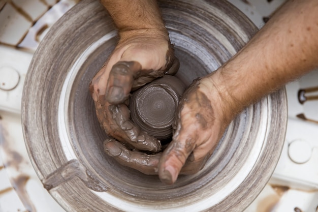 Artist makes clay pottery on a spin wheel