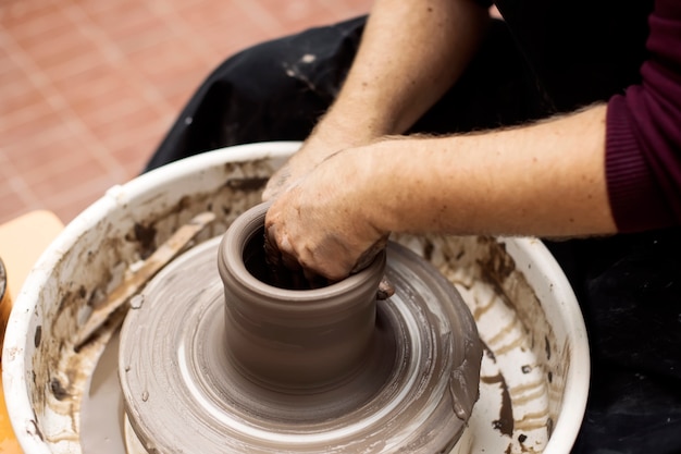 L'artista produce ceramiche di argilla su una ruota di rotazione