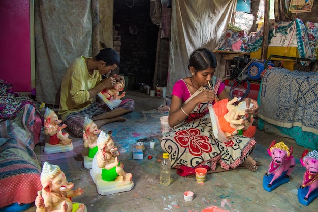 Artist making a statue and gives finishing touches on an idol of the Hindu god Lord Ganesha at an artist39s workshop for Ganesha festival