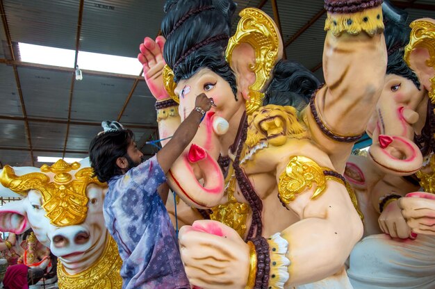 Artist making a statue and gives finishing touches on an idol of the Hindu god Lord Ganesha at an artist39s workshop for Ganesha festival