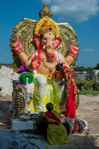 Художник делает статую и наносит последние штрихи на идол индуистского бога Господа Ганеши в мастерской художника для фестиваля Ганеши.