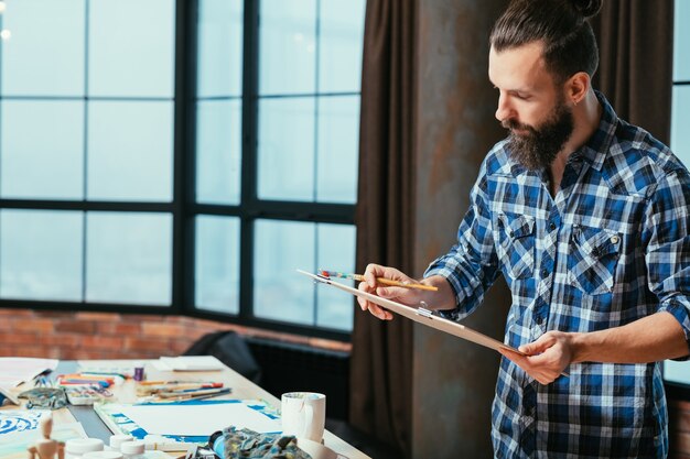 Artista che dipinge nel suo spazio di lavoro in studio