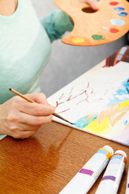 写真 テーブルに座って日本の風景を描くアーティスト