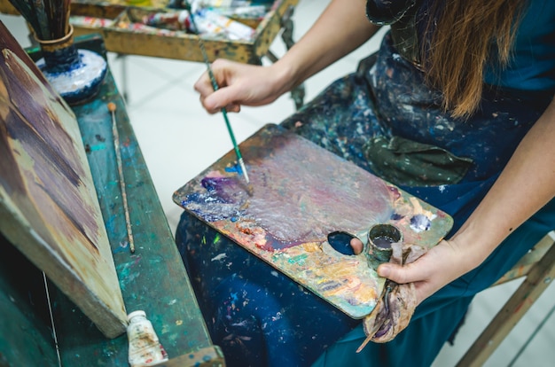 Artist painting a picture in a studio. Closeup view