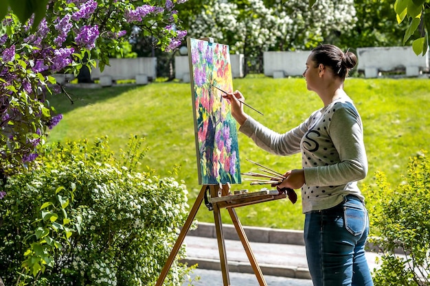 Photo the artist paints an oil painting in nature