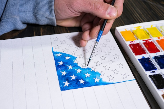 Artist paints a watercolor american flag for us independence day