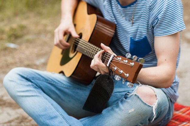 artist playing guitar in forest. bard hiking and traveller lifestyle