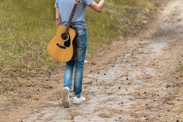 artist playing guitar in forest. bard hiking and traveller lifestyle