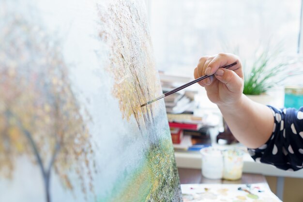 La mano dell'artista disegna la fine della pittura a olio su