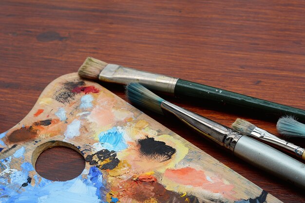 Artist's palette with colorful oil paint strokes and paintbrushes