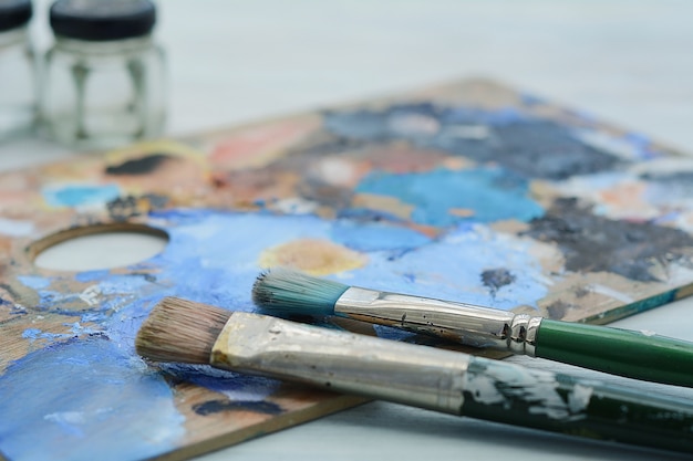 Artist's palette with colorful oil paint strokes and paintbrushes