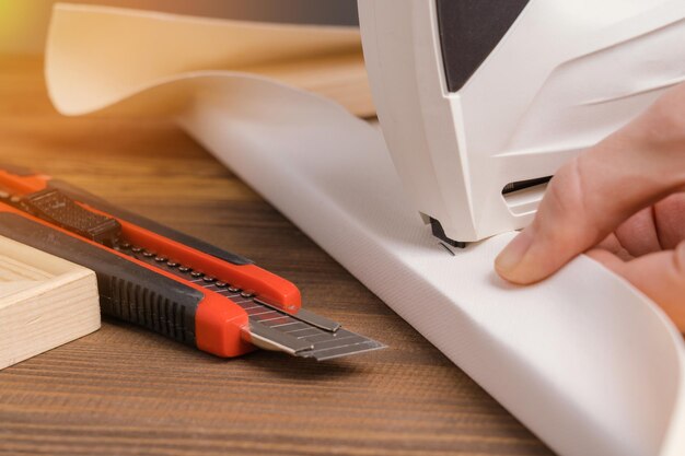 The artist in the studio stretches the canvas on a wooden stretcher with a stapler. Close-up