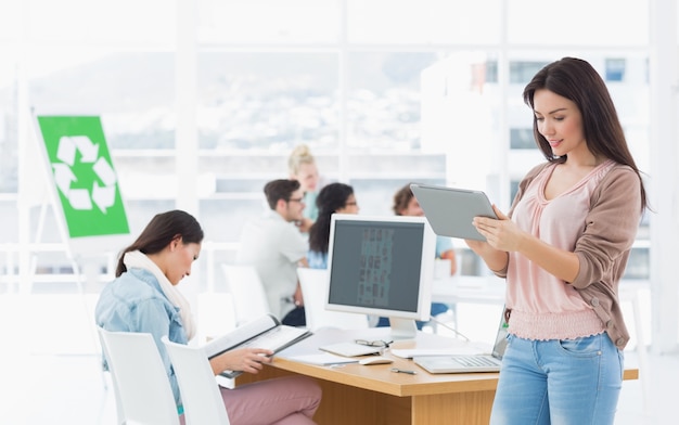 Artist using digital tablet with colleagues in at office