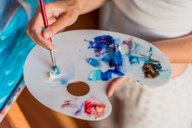 写真 さまざまな色のパレットに油絵の具を使用しているアーティスト