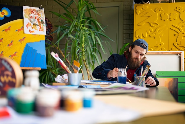 Photo artist using watercolor to paint his art in the studio