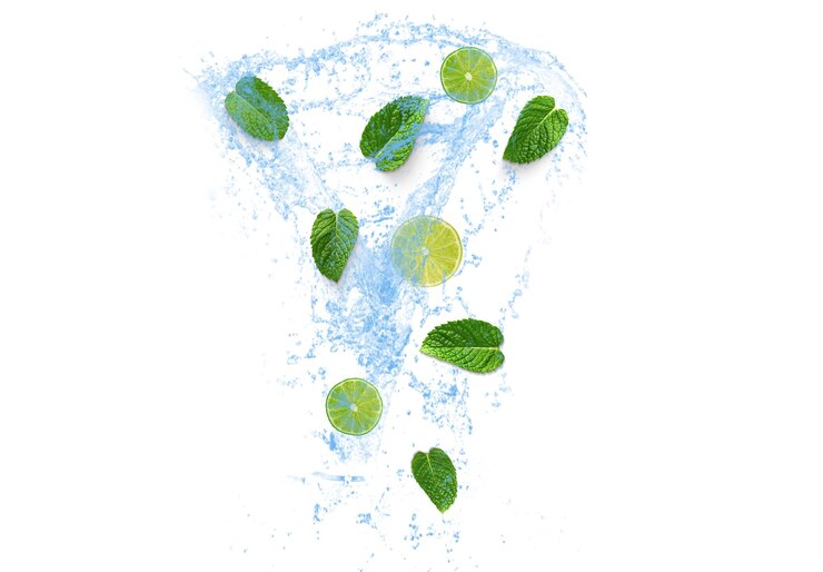 Photo artistic arrangement of mint leaves in water splash on white backdrop creating a visually refreshing and dynamic effect