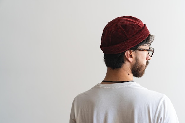 Artistic photo of a young latin man with his back turned wearing a miki hat and glasses Copy space