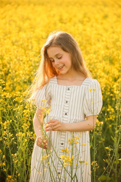 Artistic portrait of a aesthetic joyful american little child girl in the dress on a natural yellow