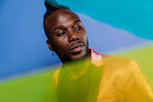 Artistic portrait with gel lights. Handsome man posing on colored backgrounds