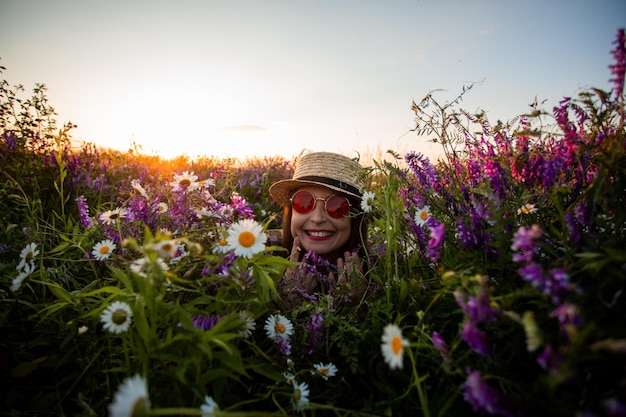 Artistic portrait of woman in red glasses among flowers