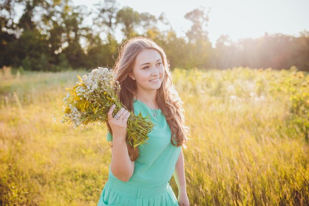 Artistic portrait of young gorgeous brunette on green meadow