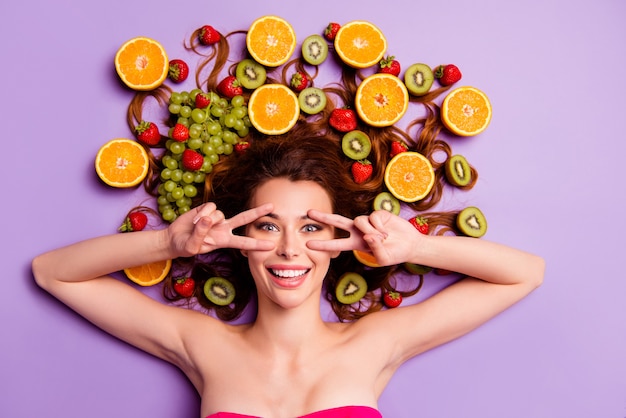 Artistic redhead woman posing with fruits in her hair