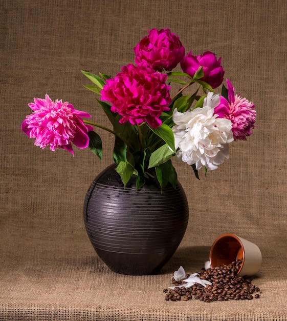 Artistic still life with peonies and cup of coffee beans