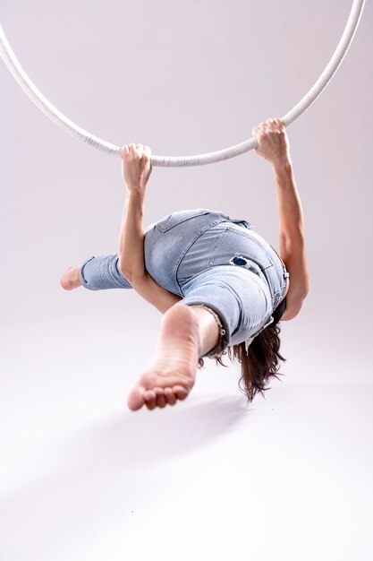 Photo artistic view of female aerial hoop gymnast exercises on an aerial hoop.