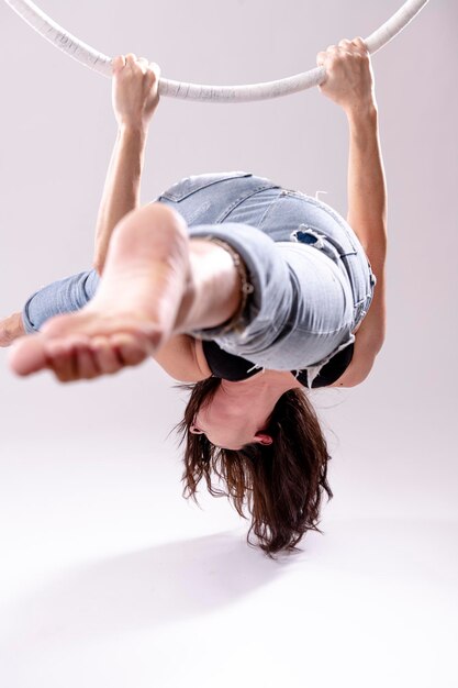 Photo artistic view of female aerial hoop gymnast exercises on an aerial hoop.