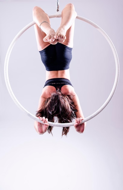 Artistic view of female Aerial hoop gymnast exercises on an Aerial hoop.