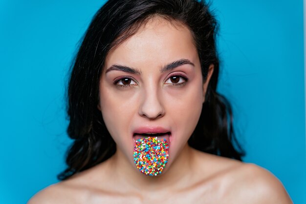 Artistiek een vrouwelijke mond met gekleurde hagelslag op haar tong