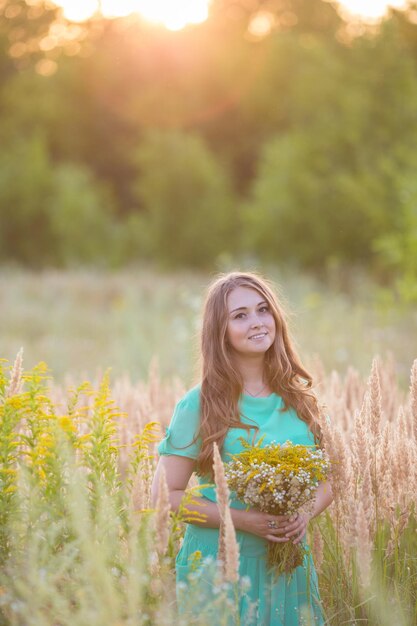 Artistiek portret van jonge schitterende brunette op groene weide