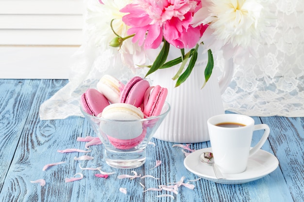 Artistiek stilleven met pioenen en kopje koffie en bloemblaadjes