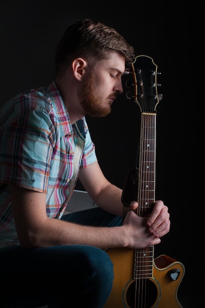 Artistieke foto van een muzikant-componist-gitarist met de creativiteit van een akoestische gitaar-cd-coveridee