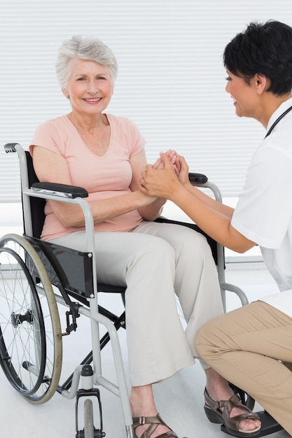Arts die aan een hogere patiënt in rolstoel spreekt