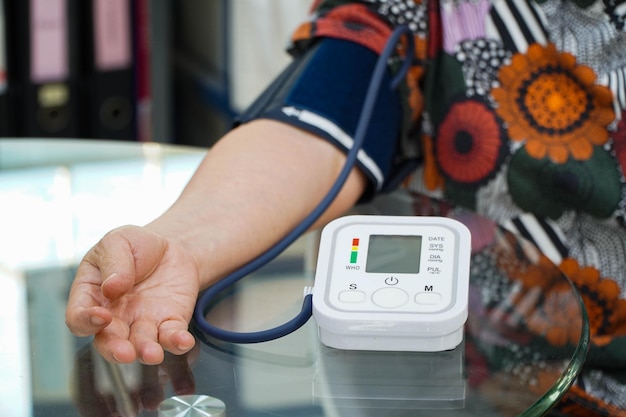 Arts die de arteriële bloeddruk van de oude vrouwelijke patiënt controleert gezondheidszorg monitoring van de bloeddruk van patiënten die een bovenarmbloeddrukmeter gebruiken in de