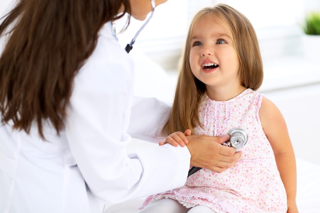 Arts die een klein meisje onderzoekt door een stethoscoop
