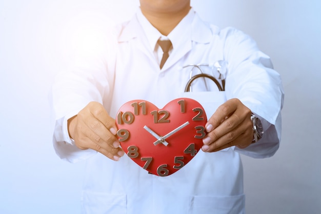 Arts die een klok, concept voor timing, medisch en gezondheidszorg houdt