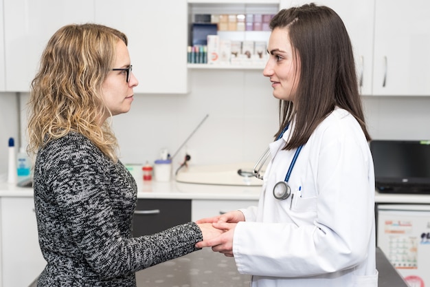 Arts die een patiënt troost terwijl het bespreken van behandeling. Geneeskunde en gezondheidszorg.