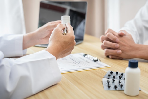 Foto arts die met de patiënt iets bespreekt die het medicijn gebruikt en behandelmethoden aanbeveelt resultaten presenteren op rapport geneeskunde en gezondheidszorgconcept