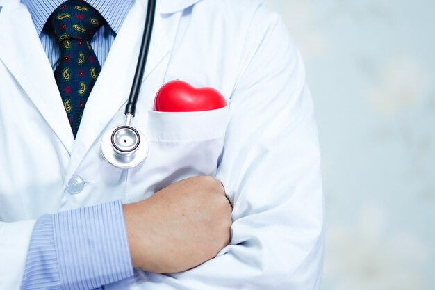 Arts die rood hart in zijn overhemdstas houdt met stethoscoop in het ziekenhuis.