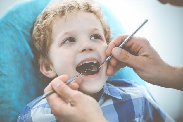 Arts en geduldig kind Jongen die zijn tanden laat onderzoeken met tandarts Geneeskundegezondheidszorg en stomatologieconcept