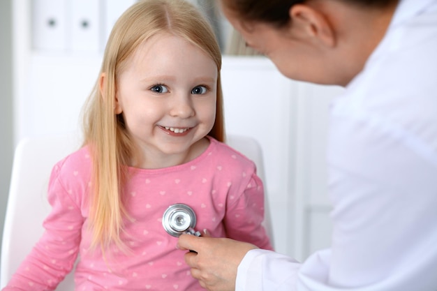 Arts en patiënt in ziekenhuis Kind wordt onderzocht door arts met stethoscoop