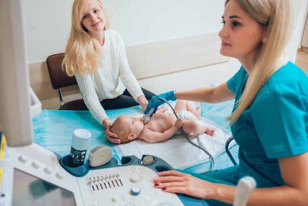 Arts en zoontje patiënt. Echografie-apparatuur. Diagnostiek. Echografie.