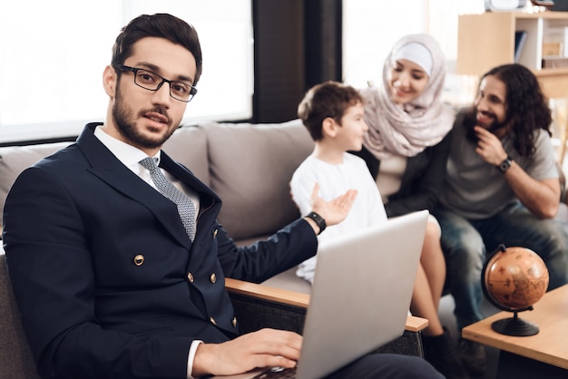 Arts houdt Laptop en wijst op familie.