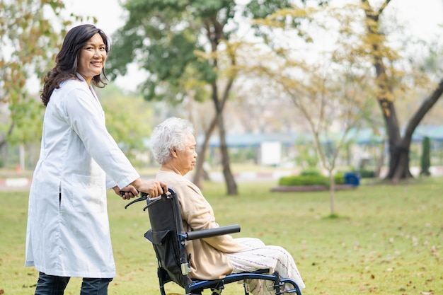 Arts hulp en zorg Aziatische senior of oudere oude dame vrouw patiënt zittend op een rolstoel in het park in verpleeg ziekenhuisafdeling, gezond sterk medisch concept.