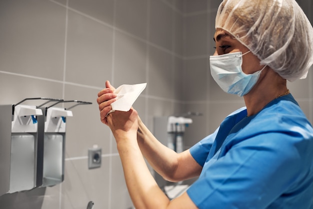 Arts hun handen wassen met behulp van een dispenser voor desinfectiemiddel